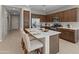 Modern kitchen features stainless steel appliances, dark wood cabinets, and a white countertop island with barstool seating at 24670 N 171St Ln, Surprise, AZ 85387