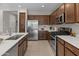 A spacious kitchen boasts stainless steel appliances, dark cabinets, and white countertops, with a tile floor at 24670 N 171St Ln, Surprise, AZ 85387