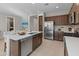 Well-lit kitchen includes stainless steel appliances, dark wood cabinetry, and a functional center island with a sink at 24670 N 171St Ln, Surprise, AZ 85387