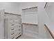 Bright, empty walk-in closet with shelves, rods and a built-in dresser at 24670 N 171St Ln, Surprise, AZ 85387