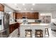 Well-lit kitchen featuring an island with seating, stainless steel appliances, and stylish wood-look flooring at 2645 W Florentine Rd, Phoenix, AZ 85086