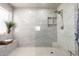 Bright, tiled shower with built-in shelves, glass enclosure, rainfall shower head, bench and decorative plant at 2645 W Florentine Rd, Phoenix, AZ 85086