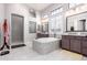 Bright bathroom featuring a soaking tub, walk-in shower, and dual vanities with granite countertops at 2799 E Waterman St, Gilbert, AZ 85297