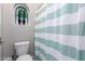 Close-up of bathroom featuring toilet and shower/tub combo with striped curtain and arched window at 2799 E Waterman St, Gilbert, AZ 85297