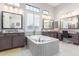 Luxurious bathroom features a large soaking tub, dual sinks, and abundant natural light through shuttered windows at 2799 E Waterman St, Gilbert, AZ 85297