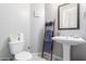 Cozy powder room with pedestal sink, decorative ladder, and neutral color palette at 2799 E Waterman St, Gilbert, AZ 85297