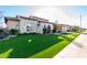 Charming stone home with arched entry gate, artificial turf lawn, and sidewalk at 2799 E Waterman St, Gilbert, AZ 85297