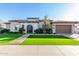 Stone home with arched entry gate, two car garage, and artificial turf lawn at 2799 E Waterman St, Gilbert, AZ 85297