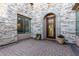 Inviting front porch with stone accent wall, elegant front door, and potted flowers at 2799 E Waterman St, Gilbert, AZ 85297