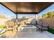 Inviting outdoor patio with a covered lounge area and cozy seating around a modern fire pit at 2799 E Waterman St, Gilbert, AZ 85297