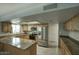 Spacious kitchen featuring stainless steel appliances, wood cabinets, granite counters, and a breakfast bar at 2902 E Escondido Ave, Mesa, AZ 85204