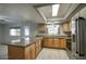 Bright kitchen with stainless steel appliances, laminate floors, granite countertops, and a breakfast bar at 2902 E Escondido Ave, Mesa, AZ 85204