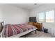 Cozy bedroom featuring wood-look floors, a bed, and a dresser with a television at 29409 N 220Th Ave, Wittmann, AZ 85361