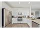 Modern kitchen with stainless steel appliances, white cabinetry, and a large sink at 29409 N 220Th Ave, Wittmann, AZ 85361