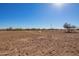 Wide open land with a dirt surface ready for construction or development under a clear blue sky at 29409 N 220Th Ave, Wittmann, AZ 85361