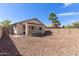 Backyard featuring desert landscaping, covered patio, and privacy fence at 30169 N Sunray Dr, San Tan Valley, AZ 85143