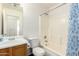 Bright bathroom with a single sink vanity, toilet, and shower-tub combo with a curtain at 30169 N Sunray Dr, San Tan Valley, AZ 85143