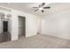 Bedroom with neutral carpeting, a ceiling fan, a walk-in closet, and white walls at 30169 N Sunray Dr, San Tan Valley, AZ 85143