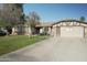 Charming single-story home featuring a well-manicured lawn and a long driveway leading to a two-car garage at 3119 S Stewart Cir, Mesa, AZ 85202