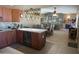 An eat-in kitchen, flowing into a dining area with a view of the brick fireplace and Gathering room at 3119 S Stewart Cir, Mesa, AZ 85202