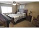 This main bedroom features a ceiling fan, neutral paint, carpet, and bedside tables with lamps at 3119 S Stewart Cir, Mesa, AZ 85202