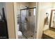 Tiled shower with glass door and an adjustable shower head at 3119 S Stewart Cir, Mesa, AZ 85202