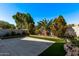 Expansive backyard with hardscape patio, artificial turf, mature trees, and privacy fencing at 3232 E Hononegh Dr, Phoenix, AZ 85050