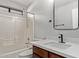 Cozy bathroom featuring a shower-tub combo and modern vanity with a black faucet and mirror at 3232 E Hononegh Dr, Phoenix, AZ 85050