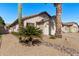 Charming single-story home featuring a two-car garage, desert landscaping, and a clear blue sky at 3232 E Hononegh Dr, Phoenix, AZ 85050