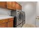 Spacious laundry area features new front loading machines, tile flooring, and overhead storage at 3232 E Hononegh Dr, Phoenix, AZ 85050