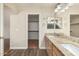 Primary bathroom featuring double sinks, wood cabinets, and a walk-in closet at 3365 W Abraham Ln, Phoenix, AZ 85027