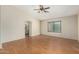 Bright living room with wood laminate flooring, ceiling fan, and archway to other rooms at 3365 W Abraham Ln, Phoenix, AZ 85027