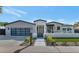 Beautiful home featuring a glass garage door, manicured lawn, and walkway leading to the front door at 3511 E Orange Dr, Phoenix, AZ 85018