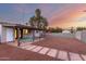 Expansive backyard featuring a covered patio, xeriscaping, and views of a colorful sunset at 3637 E Yale St, Phoenix, AZ 85008