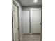 Clean hallway featuring light grey walls, modern flooring, and multiple white doors at 3645 N 69Th Ave # 67, Phoenix, AZ 85033