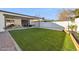 Backyard featuring a covered patio, artificial grass, and gravel landscaping at 3803 S Elm St, Tempe, AZ 85282