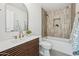 Stylish bathroom with sleek wood vanity, bronze fixtures, and a tiled shower-bathtub combo at 3803 S Elm St, Tempe, AZ 85282