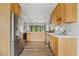 Bright kitchen featuring wood cabinets, stainless steel appliances, white countertops, subway tile backsplash, and wood grain tile floors at 3922 E Elm St, Phoenix, AZ 85018