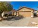 Tan single-story house with a large driveway and a well-manicured yard at 4040 E Rowel Rd, Phoenix, AZ 85050