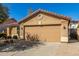 Tan single-story house with a large driveway and a well-manicured yard at 4040 E Rowel Rd, Phoenix, AZ 85050