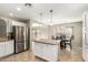 Modern eat-in kitchen features granite countertops, stainless steel refrigerator and island with storage and pendant lights at 4040 E Rowel Rd, Phoenix, AZ 85050