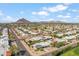 Expansive aerial view of residential area with mountain backdrop under a bright blue sky with scattered clouds at 4622 N 78Th St, Scottsdale, AZ 85251