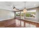 Bright living room with hardwood floors, a ceiling fan, decorative light fixture, and three large windows at 4622 N 78Th St, Scottsdale, AZ 85251