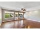 Bright living room with hardwood floors, a ceiling fan, decorative light fixture, and three large windows at 4622 N 78Th St, Scottsdale, AZ 85251