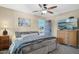 Bedroom with a ceiling fan, painting, mounted television, and an open door to the outside at 5401 E Corrine Dr, Scottsdale, AZ 85254