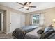 A cozy bedroom featuring a ceiling fan, closet with sliding doors, and a bright window view at 5401 E Corrine Dr, Scottsdale, AZ 85254