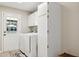 Bright laundry room features white appliances, cabinetry and a glass paneled door to the patio at 5401 E Corrine Dr, Scottsdale, AZ 85254