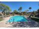 A sparkling blue community pool with lounge chairs and palm trees on a sunny day at 5401 E Van Buren St # 1068, Phoenix, AZ 85008