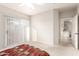 Carpeted bedroom featuring a ceiling fan, sliding door to the balcony, and adjoining bath entrance at 5401 E Van Buren St # 2050, Phoenix, AZ 85008