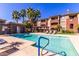 Community pool surrounded by palm trees with multiple lounge chairs available for residents at 5401 E Van Buren St # 2050, Phoenix, AZ 85008